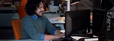 man smiling at computer screen