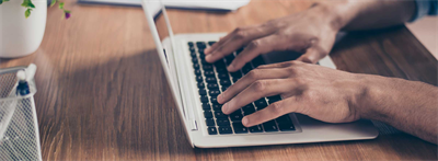 Hands typing on a laptop